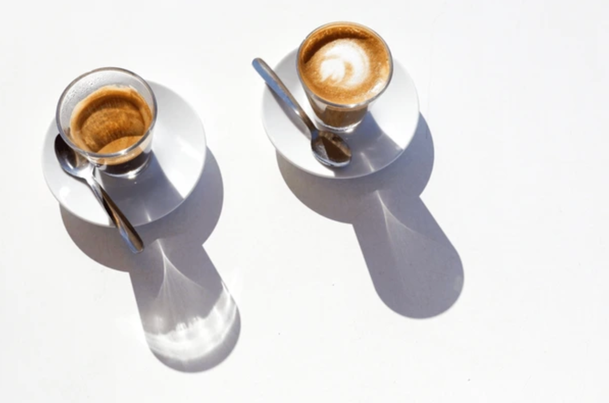 Two cups of coffee on flat-lay white background