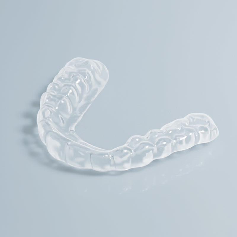 Clear slim night guard for teeth grinding and TMJ relief on white background
