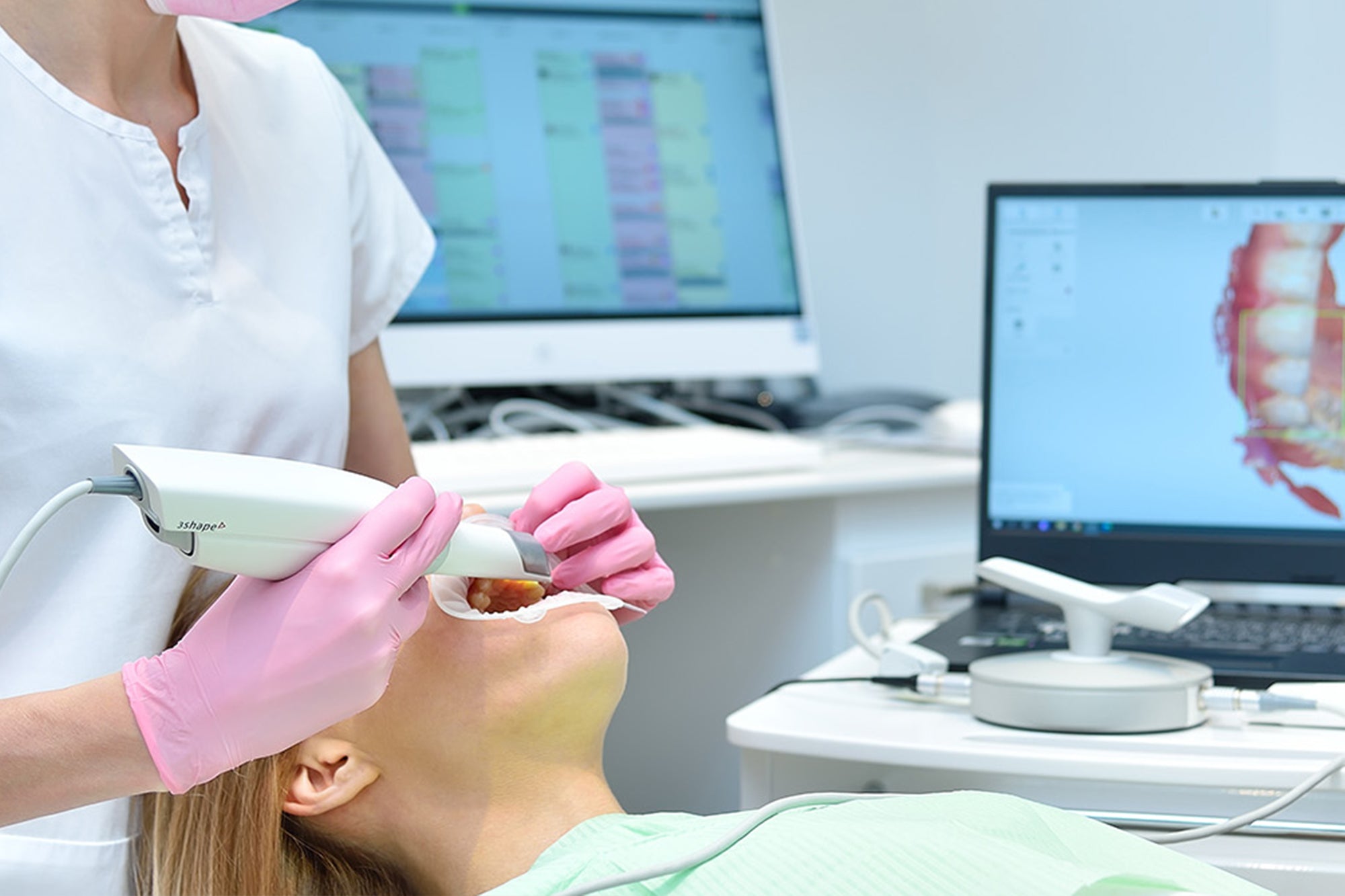 Dental examination with a patient receiving an oral inspection and digital imaging.