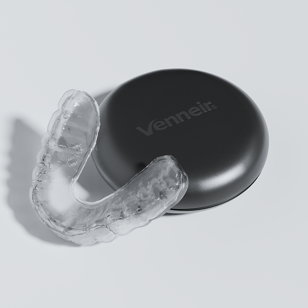 Clear slim night guard for teeth grinding and TMJ relief on light blue background