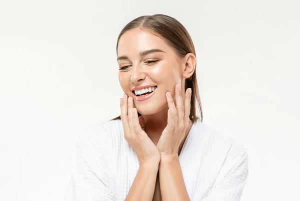 Woman holding her face smiling on white background