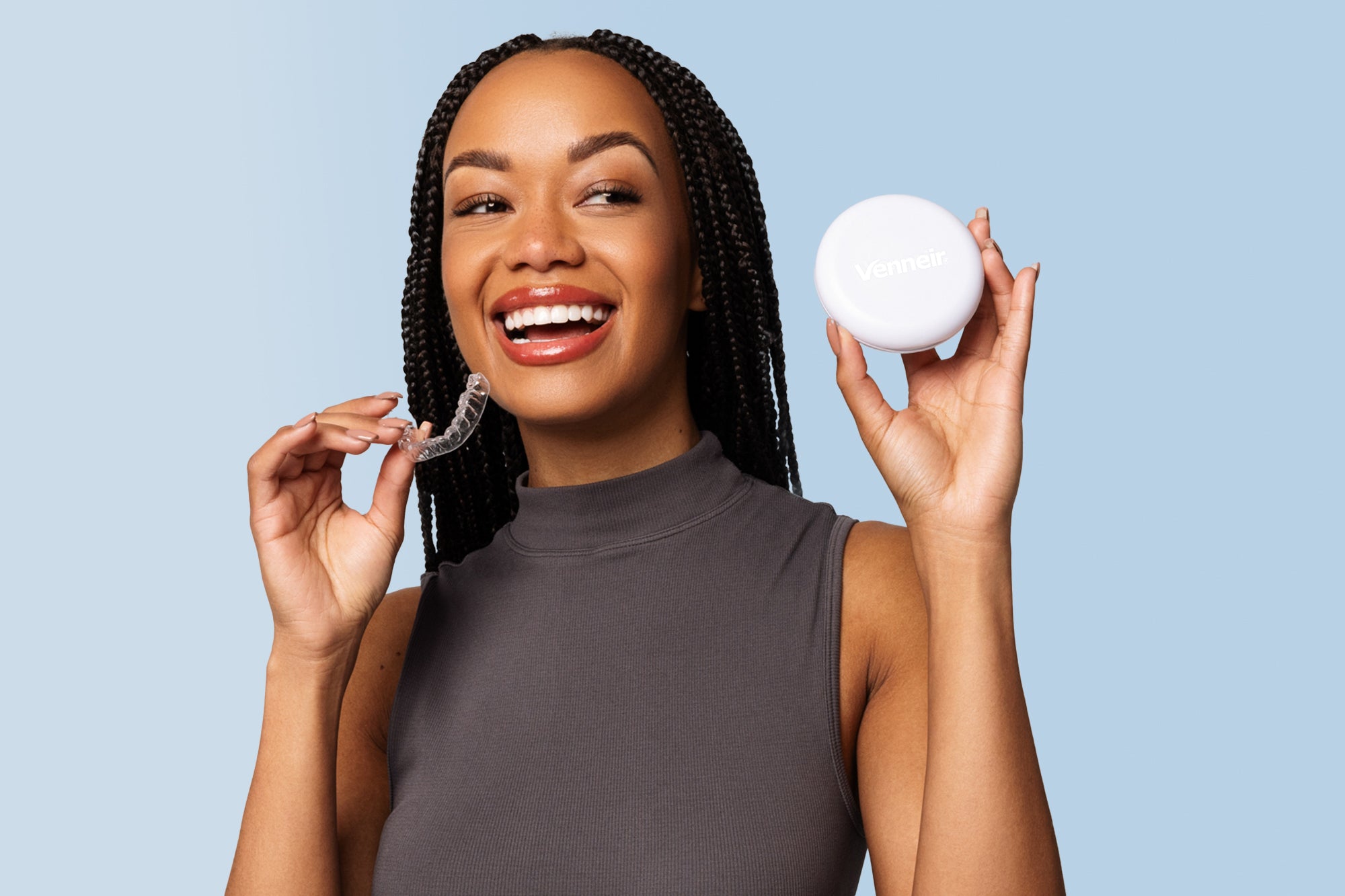 Woman holding retainer and storage case with Venneir branding and blue background