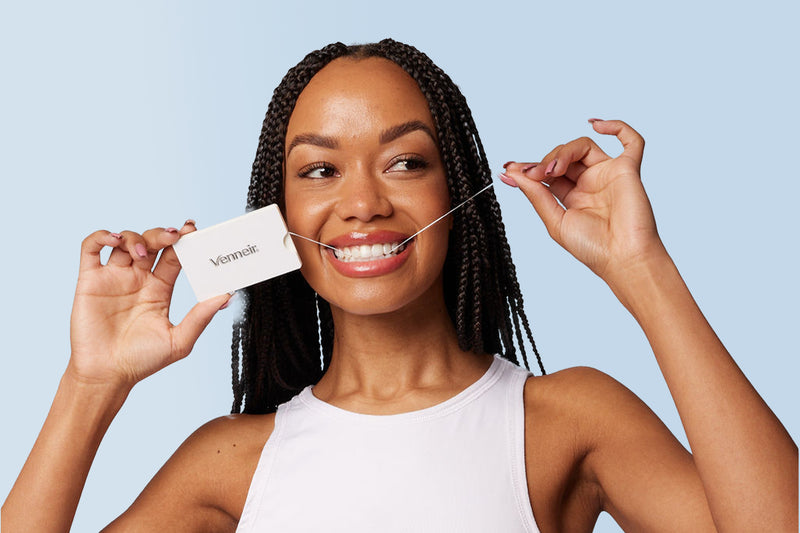 Woman using dental tape with Venneir branding and light blue background