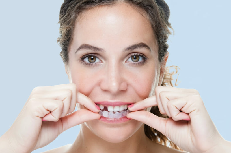 Woman wearing missing tooth pontic essix retainer with fake tooth