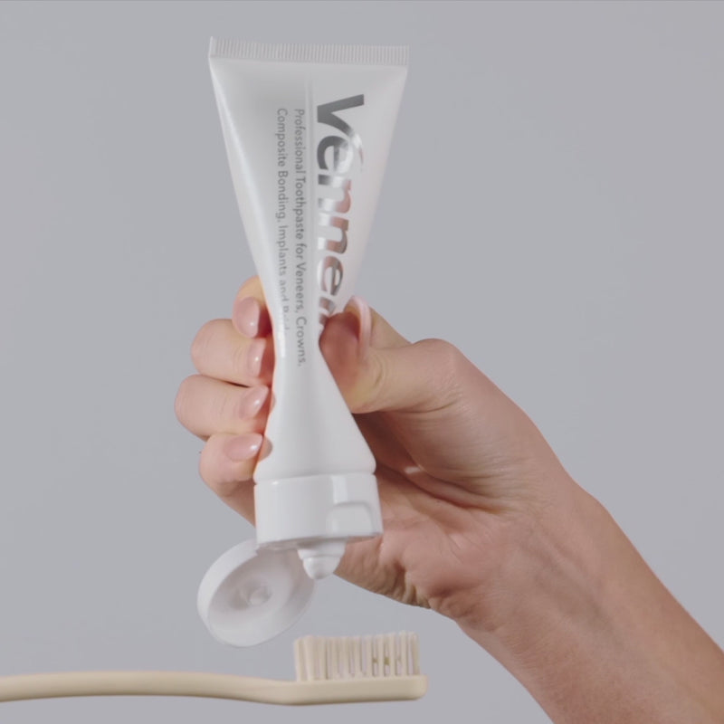 woman squeezing toothpaste out a Venneir tube