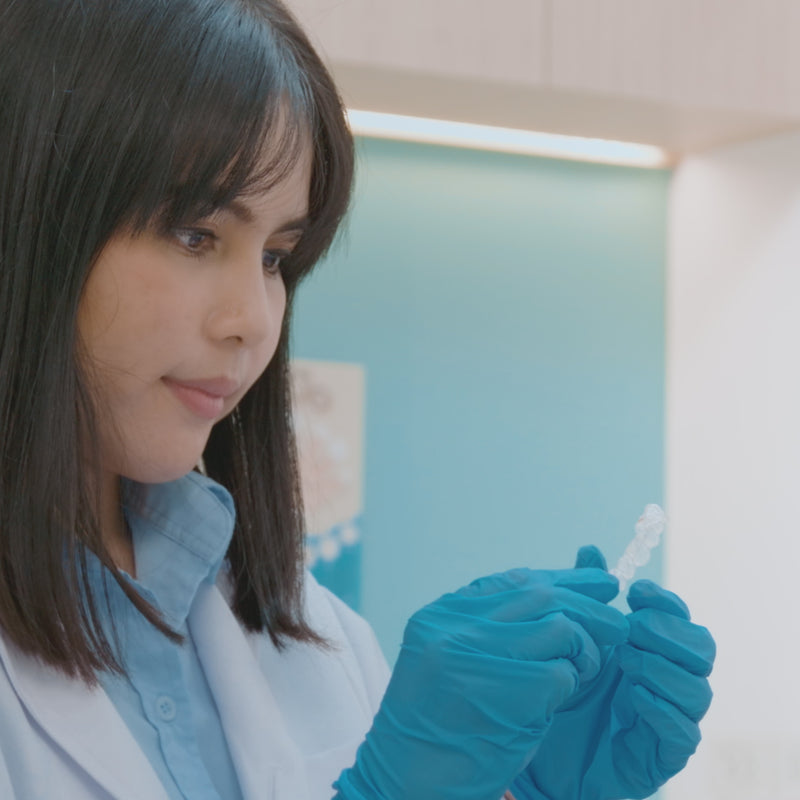 Dental professional holding retainers wearing gloves