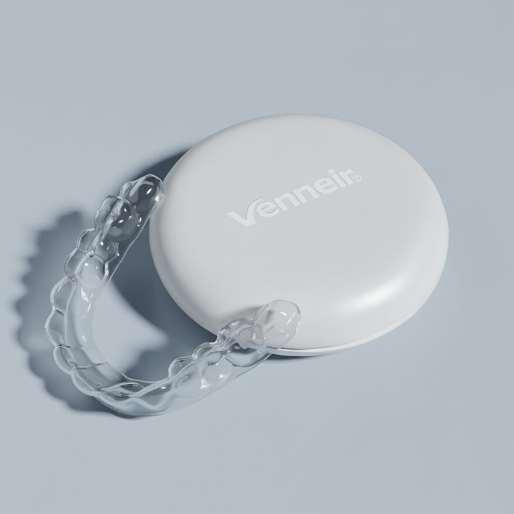 Clear dental retainer with white case on a light gray background