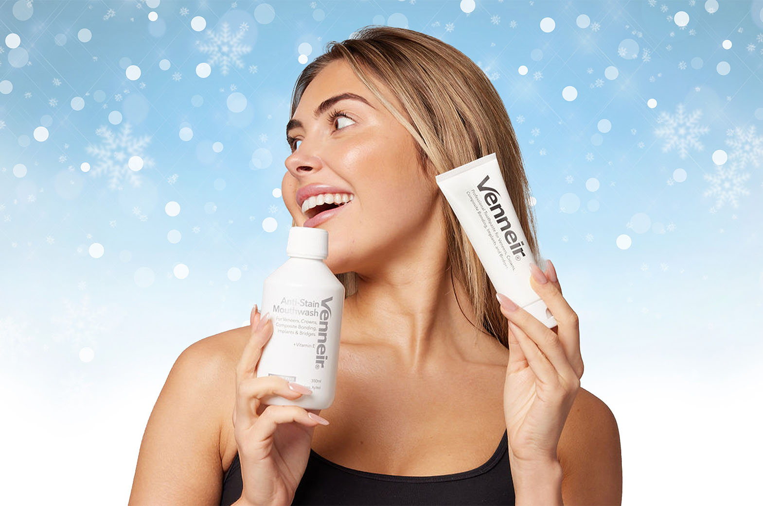 Woman holding Venneir mouthwash and toothpaste products against a snowy background